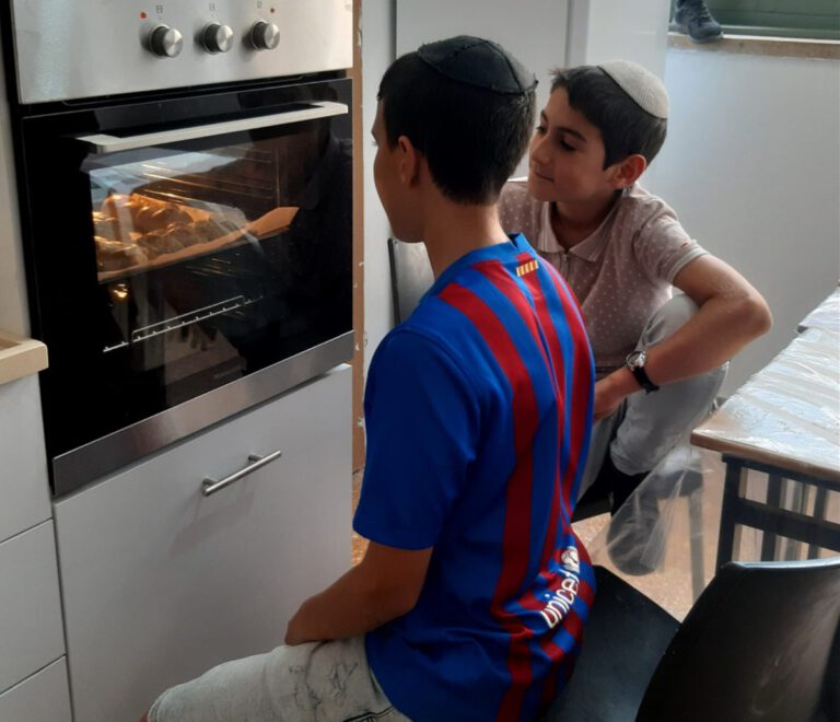 תלמידים ממתינים למאפה שנאפה בתנור במטבח החינוכי של בית הספר או"ת אריאל